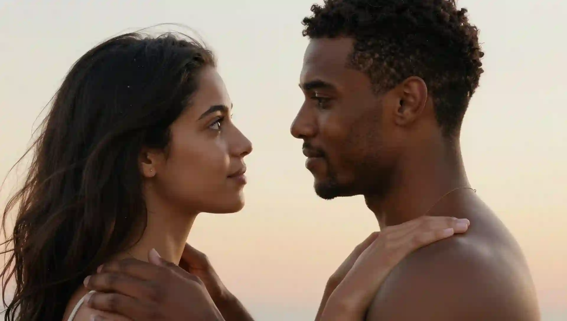 romantic-couple-gaze An illustration of a young Black man and a woman with long dark hair looking lovingly at each other, with his hands gently resting on her shoulders against a soft, warm gradient background.