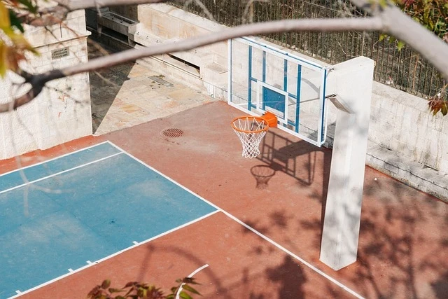 An empty urban basketball court symbolizing the fragile promise of safe recreation in city neighborhoods
